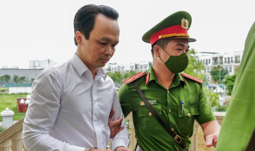 Trinh Van Quyet, a prominent Vietnamese business tycoon, is escorted to a court for his trial of defrauding stockholders, in Hanoi, Vietnam, July 22, 2024. (AP Photo/Anh Tuc)