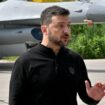 Le président ukrainien Volodymyr Zelensky devant un chasseur F-16 lors d'une cérémonie dans un lieu tenu secret en Ukraine, le 4 août 2024