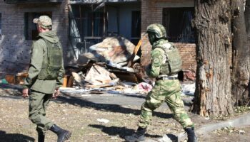 Volontaires russes en treillis, arpentent les rues de Koursk, endommagées par les frappes ukrainiennes.