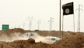 Islamic State militants pass a checkpoint bearing the group's trademark black flag in Iraq. File pic: AP