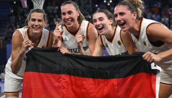 Feiern mit der Fahne: Die 3x3-Basketballerinnen. Foto: Sina Schuldt/dpa