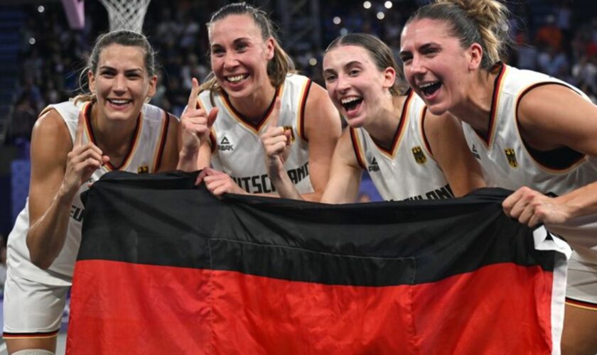 Feiern mit der Fahne: Die 3x3-Basketballerinnen. Foto: Sina Schuldt/dpa