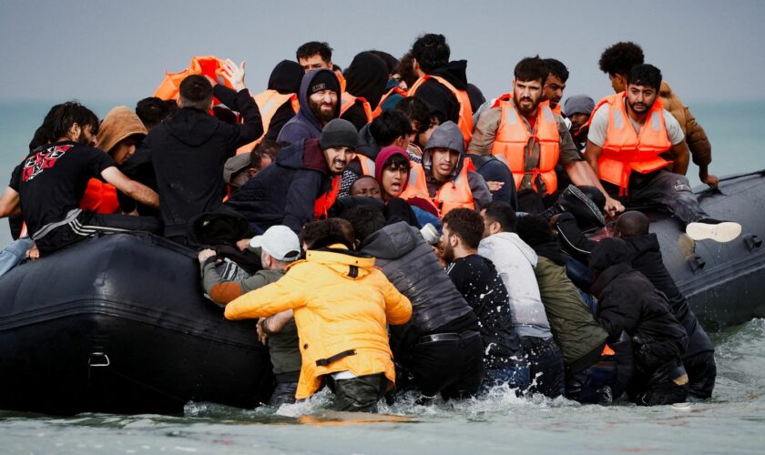 Migrants attempting to cross the English Channel to reach Britain get on an inflatable dinghy as the French police and gendarmes officers patrol on the beach of the Slack dunes in Wimereux, France, September 4, 2024. REUTERS/Benoit Tessier TPX IMAGES OF THE DAY