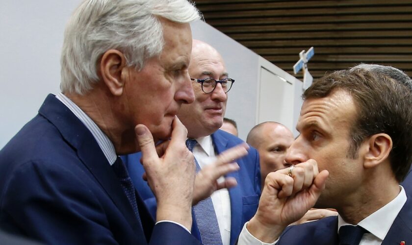 Le Président Emmanuel Macron (d) s'entretient avec le commissaire européen Michel Barnier (g) lors du salon de l'Agriculture le 23 février 2019