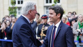 Michel Barnier sert la main du Premier ministre sortant Gabriel Attal lors de la cérémonie de passation de pouvoir à l'Hotel Matignon à Paris, le 5 septembre 2024