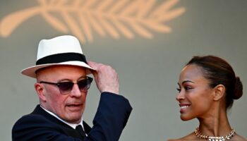 Le réalisateur français Jacques Audiard (g) et l'actrice américaine Zoe Saldana arrivent à la projection du film "Emilia Perez" lors de la 77e édition du Festival de Cannes, dans le sud de la France, le 18 mai 2024