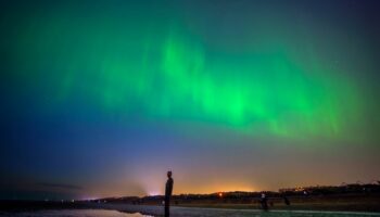 The aurora borealis, also known as the northern lights, glow on the horizon at Another Place by Anthony Gormley, Crosby Beach, Liverpool , Merseyside . Picture date: Friday May 10, 2024. PA Photo. See PA story WEATHER Aurora. Photo credit should read: Peter Byrne/PA Wire