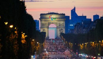 Des athlètes de différentes délégations défilent sur l'avenue des Champs-Elysées avec l'Arc de Triomphe en arrière-plan, lors de la cérémonie d'ouverture des Jeux Paralympiques de Paris 2024, à Paris, le 28 août 2024. (Photo Dimitar DILKOFF / AFP)