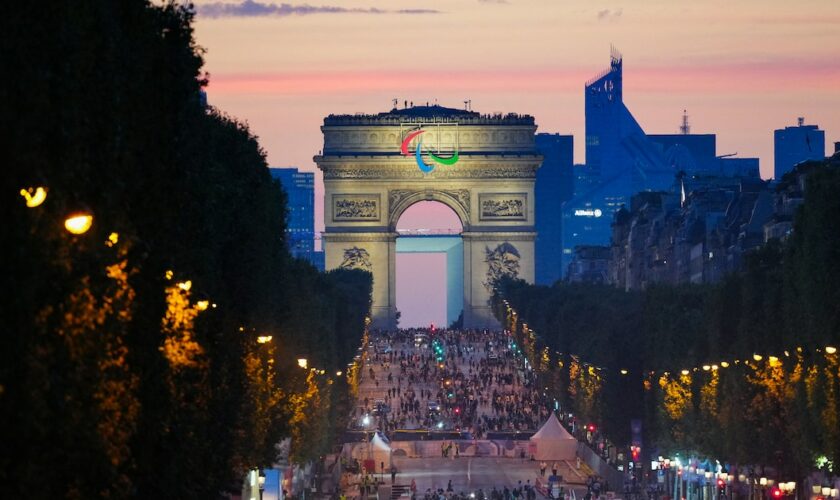 Des athlètes de différentes délégations défilent sur l'avenue des Champs-Elysées avec l'Arc de Triomphe en arrière-plan, lors de la cérémonie d'ouverture des Jeux Paralympiques de Paris 2024, à Paris, le 28 août 2024. (Photo Dimitar DILKOFF / AFP)