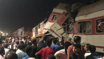 People surround two passenger trains which collided. Pic: AP