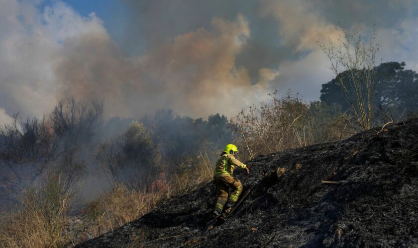 A firefighter works in the area around a fire after the military said it fired interceptors at a missile launched from Yemen that landed in central Israel on Sunday, Sept. 15, 2024. (AP Photo/Ohad Zwigenberg)