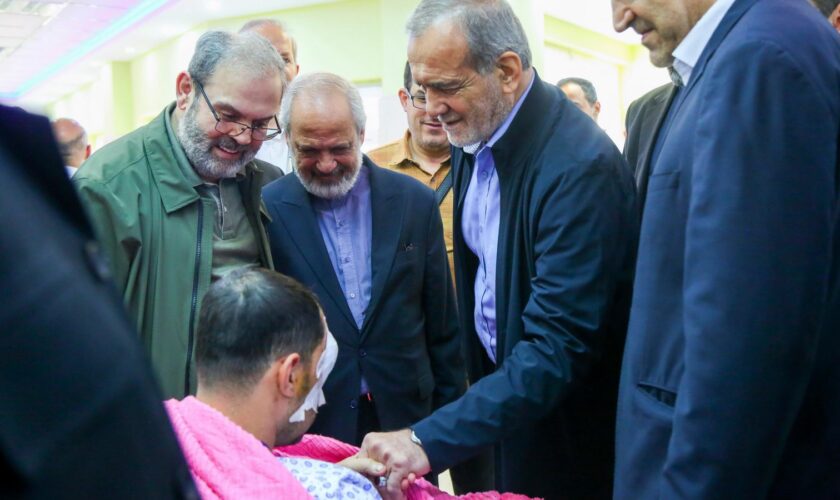 In this photo released by the Iranian Presidency Office, President Masoud Pezeshkian, second right, visits a victim of Lebanon's recent attacks at a hospital in Tehran, Iran, Friday, Sept. 20, 2024. (Iranian Presidency Office via AP)