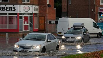 Vehicles drive through flood water in Perry Bar, Birmingham. Pic: PA