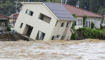 A house leans as a swollen river undermines the ground in Suzu, Japan, Sunday, Sept. 22, 2024, following heavy rain in central Japan's Noto peninsula area, where a devastating earthquake took place on Jan. 1. (Kasumi Fukudome/Kyodo News via AP)