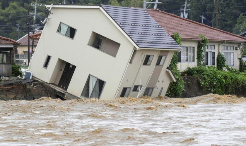 A house leans as a swollen river undermines the ground in Suzu, Japan, Sunday, Sept. 22, 2024, following heavy rain in central Japan's Noto peninsula area, where a devastating earthquake took place on Jan. 1. (Kasumi Fukudome/Kyodo News via AP)