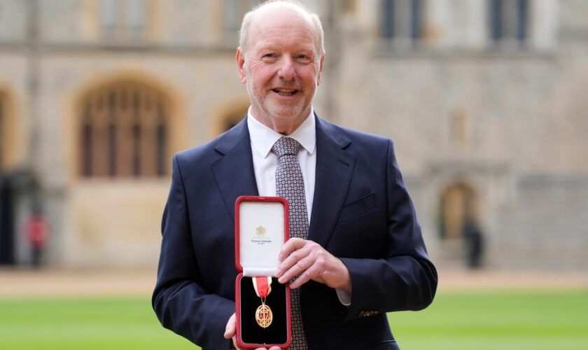 Sir Alan Bates shows off his award outside Windsor Castle. Pic: PA