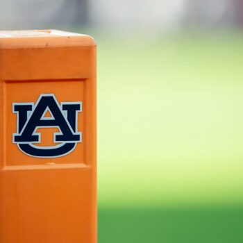 Auburn cheerleader knocks down Oklahoma player running onto field while performing stunts