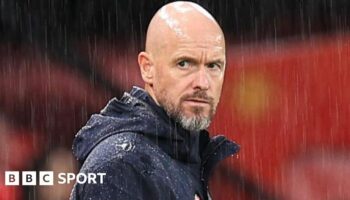 Manchester United manager Erik ten Hag stands on the touchline in the rain at Old Trafford