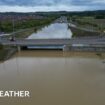 A dual carriageway completely covered by flood water under a bridge