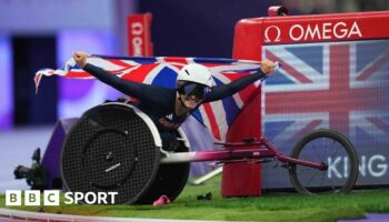 Sammi Kinghorn holds aloft a Union flag after winning the T53 100m at the Paris Paralympics