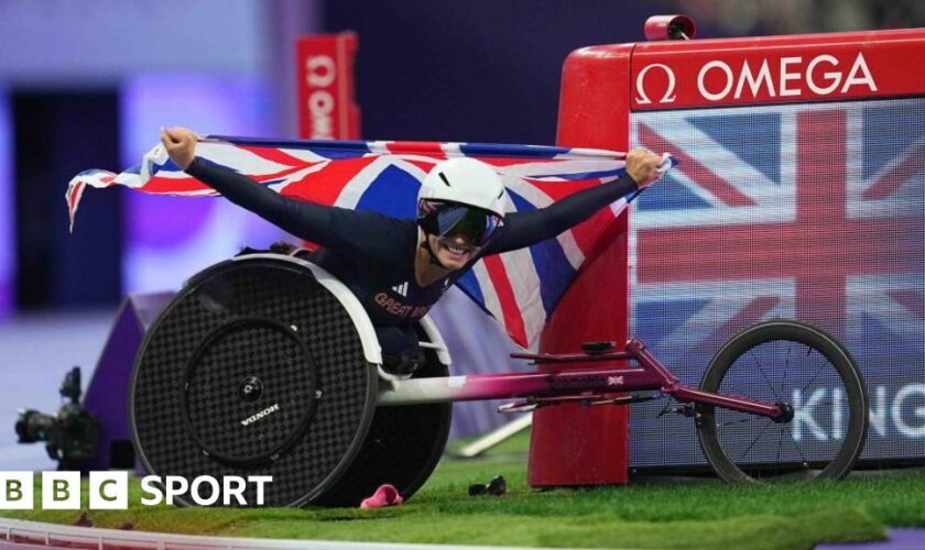 Sammi Kinghorn holds aloft a Union flag after winning the T53 100m at the Paris Paralympics