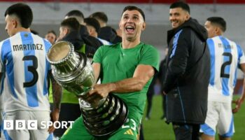 Argentina goalkeeper Emiliano Martinez holds a replica Copa America trophy against his crotch