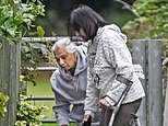 Wife of grandfather, 80, 'kicked to death yards from his front door' visits floral tributes laid next to park where he was killed - as police continue to quiz boy, 14, over 'murder'