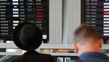 Des passagers devant un tableau d'affichage de l'aéroport Ben Gourion de Tel-Aviv, le 6 août 2024