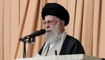 Iran's supreme leader holds rifle as he warns about possible future missile attack