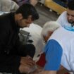 Le docteur Bertrand Chatelain de l'ONG Médecins du Monde (MdM) examine un réfugié lors d'une maraude dans le camp de migrants du quartier Stalingrad à Paris, le 12 juillet 2023. (Photo par JULIEN DE ROSA / AFP)