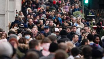 People wear face masks as they walk in Regent Street, in London, Sunday, Nov. 28, 2021. Britain's Prime Minister Boris Johnson said it was necessary to take ...targeted and precautionary measures... after two people tested positive for the new variant in England. He also said mask-wearing in shops and on public transport will be required. (AP Photo/Alberto Pezzali)