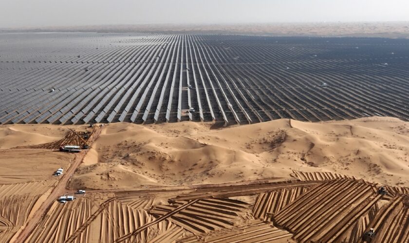 Des véhicules préparent le terrain avant l'installation de nouveaux panneaux solaires pour la centrale énergétique de Ningxia, dans le désert de Tengger, en Chine, le 9 décembre 2023