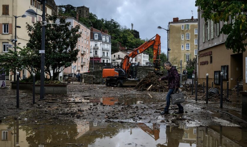 Un habitant traverse une rue inondée d'Annonay, en Ardèche, le 17 octobre 2024