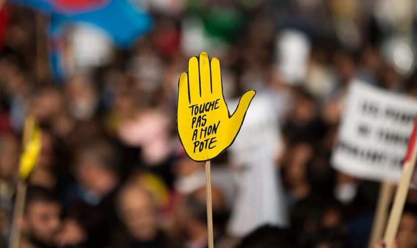 Le logo "Touche pas à mon pote" de SOS Racisme lors d'une manifestation à Paris, le 11 octobre 2015, en mémoire à la centaine de victimes d'un attentat-suicide à Ankara la veille